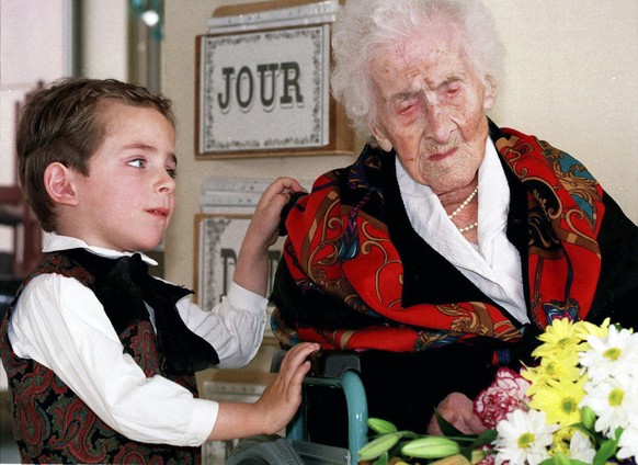 FILE - In this Feb. 12, 1997 file photo shows Thomas, 5, looks at Jeanne Calment after he brought her flowers at her retirement home in Arles, southern France. Calment, believed to be the world&#039;s ...