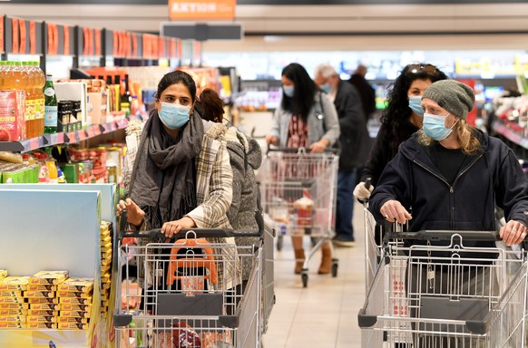 ABD0019_20200406 - WIEN - ÖSTERREICH: Kunden mit Mund- und Nasenschutz in einem Supermarkt in Wien am Montag, 6. April 2020. Seit heute ist das Tragen eines solchen Schutzes in Supermärkten ab einer V ...