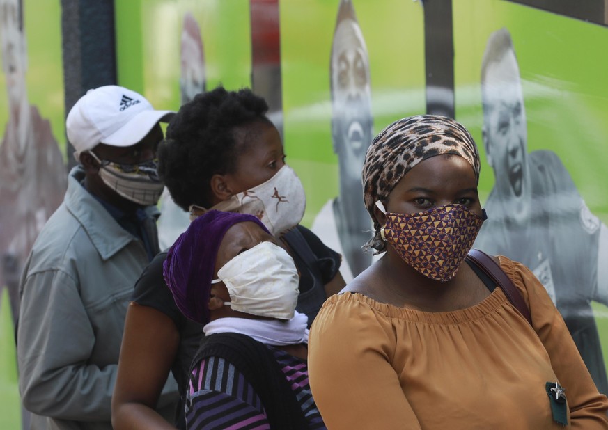 People wearing face masks queue at a South African Social Security Agency (SASSA) to collect their government grant in Cape Town South Africa, Monday, May 11, 2020. South Africa&#039;s Western Cape pr ...