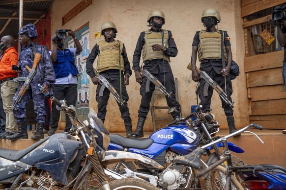 Security forces stand outside a polling station in Kampala, Uganda, Thursday, Jan. 14, 2021. Ugandans are voting in a presidential election tainted by widespread violence that some fear could escalate ...