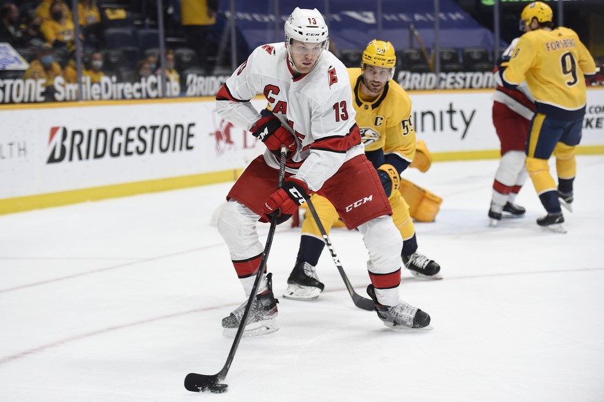 Carolina Hurricanes left wing Warren Foegele (13) controls the puck in front of Nashville Predators defenseman Roman Josi (59) during the first period of an NHL hockey game Saturday, May 8, 2021, in N ...