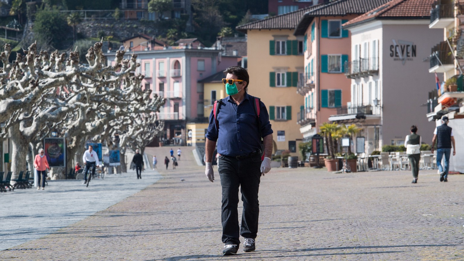 Ein Mann mit Hygienemaske laeuft an der Uferpromenade von Ascona, am Samstag, 4. April 2020. Bundesrat und Tessiner Regierung hatten schon fuer das vergangene Wochenende explizit dazu aufgerufen, nich ...