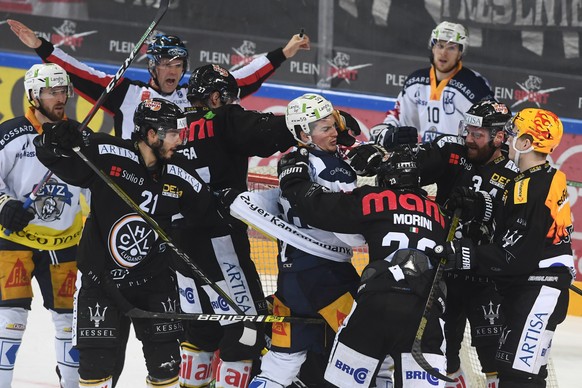 Zug&#039;s player Dario Simion, center, fights with Lugano&#039;s player Giovanni Morini, right, during the preliminary round game of National League Swiss Championship 2018/19 between HC Lugano and E ...