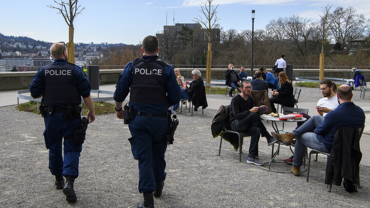 Zwei Polizisten kontrollieren, dass das Social Distancing waehrend der Coronavirus (Covid-19) Pandemie eingehalten wird, am Dienstag, 17. Maerz 2020 auf der Bundesterrasse in Bern. (KEYSTONE/Anthony A ...