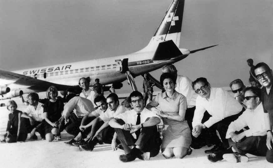Jean Michel Weiss (Mitte, mit Krawatte) sitzt neben Beta Steinegger (Mitte, kniend) und weiteren Geiseln vor der entführten Swissair-Maschine. Das Foto entstand bei der Pressekonferenz, welche die pal ...